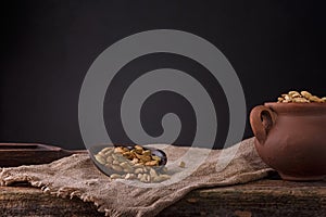 Cardamom in a wooden scoop . Cardamom in a wooden shovel on a gray wooden background