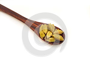 Cardamom in a wooden spoon white background