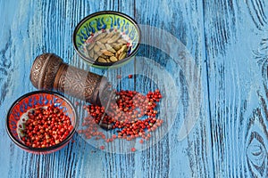 Cardamon and pink pepper on table with mill