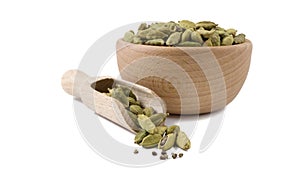 Cardamon seeds in wooden bowl and scoop isolated on white background. Spices and food ingredients