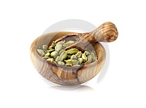 Cardamon in wooden bowl on white background. Spices isolated