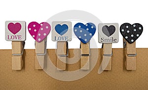 Cardboard background with clips with heart and lettering LOVE avd SMILE