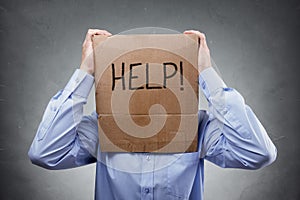 Cardboard box on businessman head ask for help