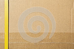 Cardboard box closed by shipping packaging tape and strapping