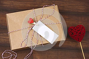 cardboard box with clothpin with red heart and empty white label