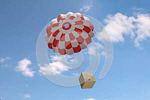 Cardboard box descending by parachute on a blue sky background. Shipping concept. 3d illustration