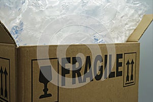 Cardboard box filled with bubble wrap and the sign fragile on it