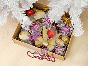 Cardboard box full of various Christmas decorations and a bead garland