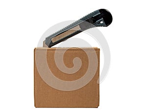 The cardboard box is opened with a knife.