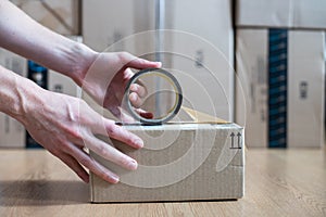 Cardboard box package, shipping concept: Preparing a parcel for delivery