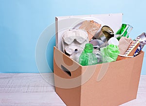 In a cardboard box plastic, glass bottles, cans, paper. The concept of separate sorting of garbage, environmental protection