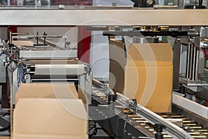 Cardboard box of product packaging is moving on conveyor belt of automatic packing machine in the manufacturing factory ready for