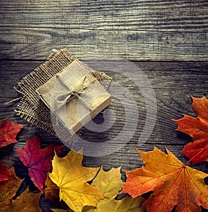 Cardboard box tied with string on a bow on a wooden background i