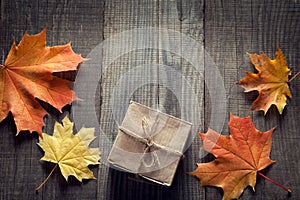 Cardboard box tied with string on a bow on a wooden background i