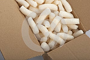 Cardboard box with yellow packing styrofoam peanuts