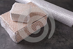 Cardboard boxes with bubble wrap on dark grey table