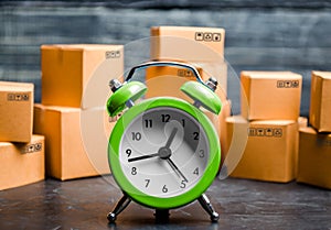 Cardboard boxes and clock. Time of delivery. Limited supply, shortage of goods in stock, hype and consumer fever. Time of delivery