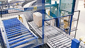 Cardboard boxes on conveyor belt in factory. Clip. Production line on which the boxes move in a spiral