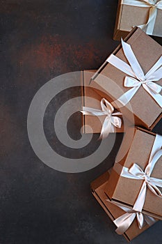 Cardboard boxes on a dark background. Gift delivery. The cardboard holiday box is tied with a ribbon. Festive packaging