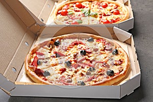 Cardboard boxes with delicious pizzas on table