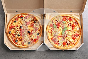 Cardboard boxes with delicious pizzas on table