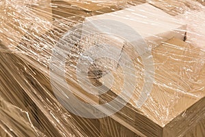 Cardboard boxes with goods or building materials and wrapped in packaging film, close-up