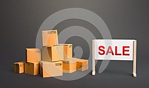 Cardboard boxes with goods and a sale stand. Big sale discounts on favorable terms. Shopping event. Marketing advertising campaign