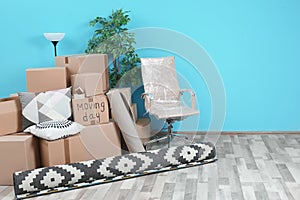 Cardboard boxes and household stuff in empty room, space for text