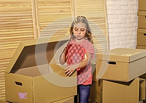 Cardboard boxes - moving to new house. happy child cardboard box. purchase of new habitation. happy little girl with toy