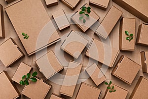 Cardboard boxes from recyclable materials with green leaves. Responsible consumption, eco friendly packaging, zero waste