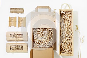 Cardboard boxes with shredded paper inside, paper bag and small gift boxes