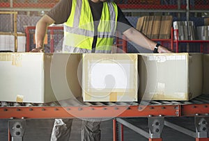 Cardboard boxes sorting on rollers conveyor belt. Worker moving boxes into storage warehouse. manufacturing warehouse.