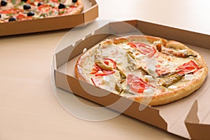 Cardboard boxes with tasty pizzas on table