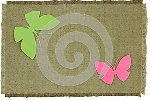 Cardboard butterfly on green coarse cloth