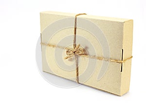 Cardboard carton wrapped with brown paper and tied with cord