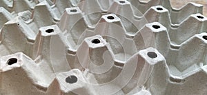 Cardboard container for eggs close-up. Smooth rows, forms for laying eggs. Abstraction with convex and indented elements.