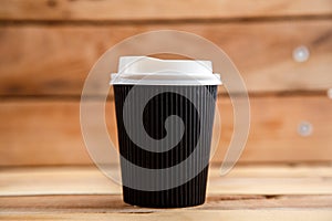 Cardboard disposable cups isolated on a wooden background. Front view