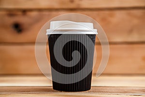 Cardboard disposable cups isolated on a wooden background. Front view