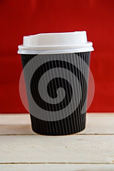 Cardboard disposable cups isolated on a wooden background. Front view