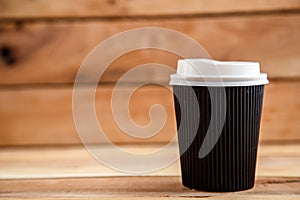 Cardboard disposable cups isolated on a wooden background. Front view