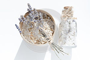 Cardboard jar with oatmeal and sea salt and a small bouquet of lavender. Sea salt in glass jar with cork stopper.