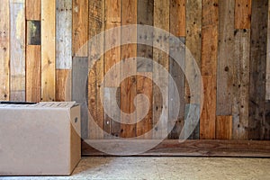 cardboard moving boxes in empty room with wooden wall background and copy space, moving in new flat or house concept, retro design