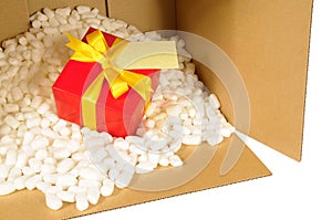 Cardboard packing box with red gift inside, polystyrene nuts, address label