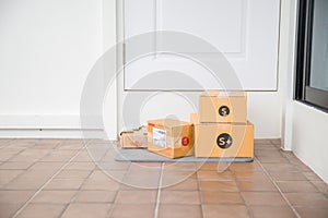 Cardboard parcel box near door on floor. Online shopping, boxes delivered to your front door. Easy to steal when nobody is home.