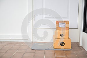 Cardboard parcel box near door on floor. Online shopping, boxes delivered to your front door. Easy to steal when nobody is home.