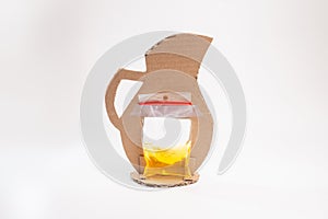 Cardboard pitcher craft: plastic bag with yellow colored water affixed to cut out piece