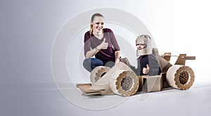 Cardboard racing car and happy family. thumbs up.