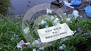 Cardboard with say yes to recycling phrase lying on open dumping among waste