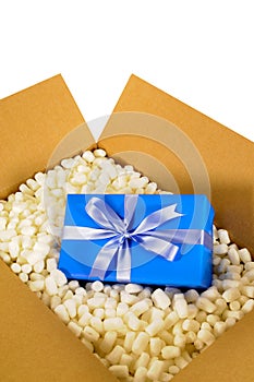 Cardboard shipping box, blue surprise gift inside, polystyrene packing pieces, vertical