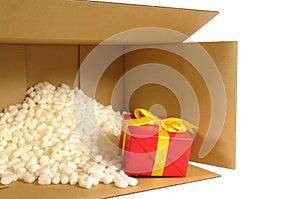 Cardboard shipping box, smallred gift inside, polystyrene packing nuts